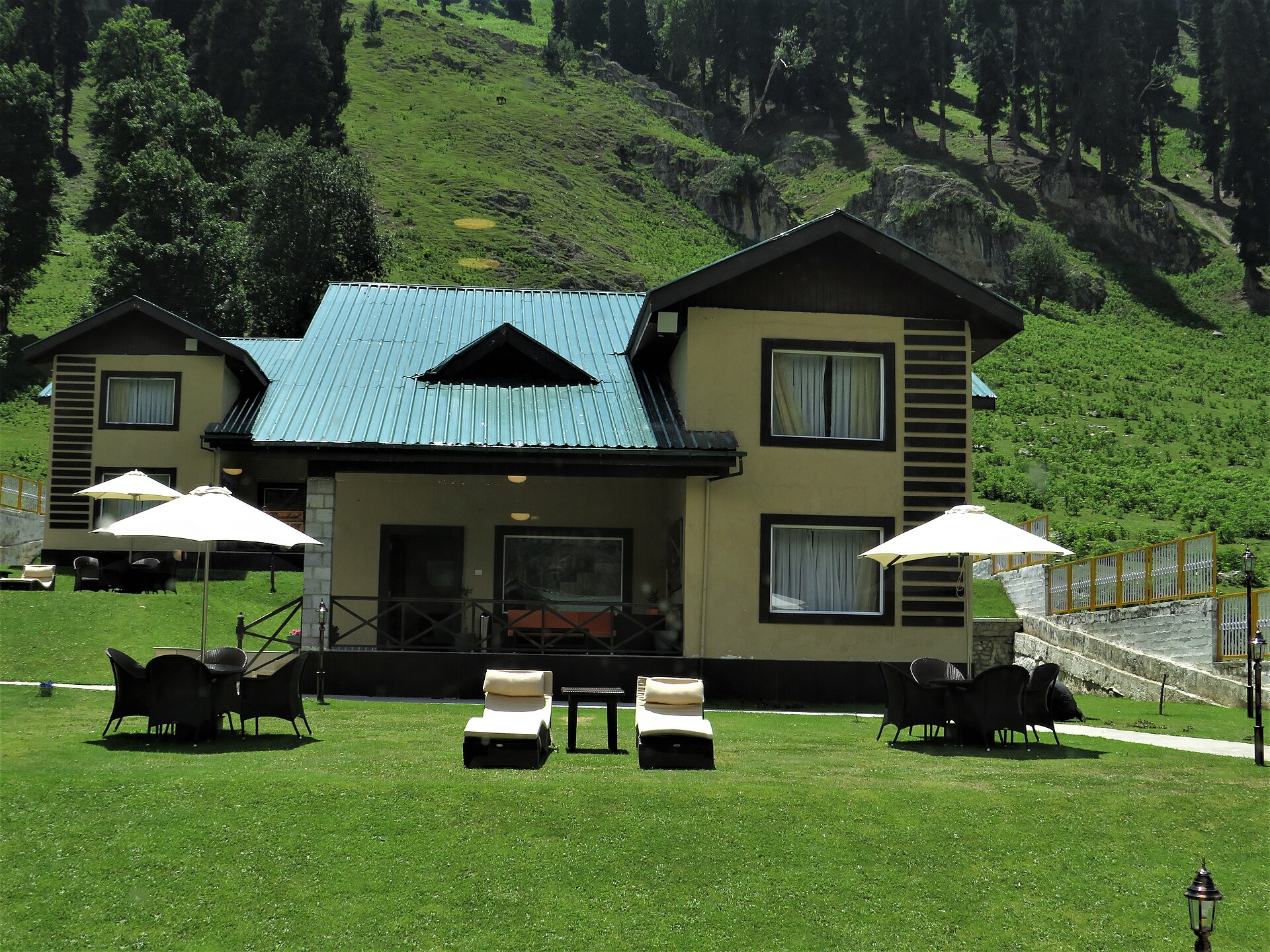 A hotel room balcony overlooking the Kashmir mountains.
