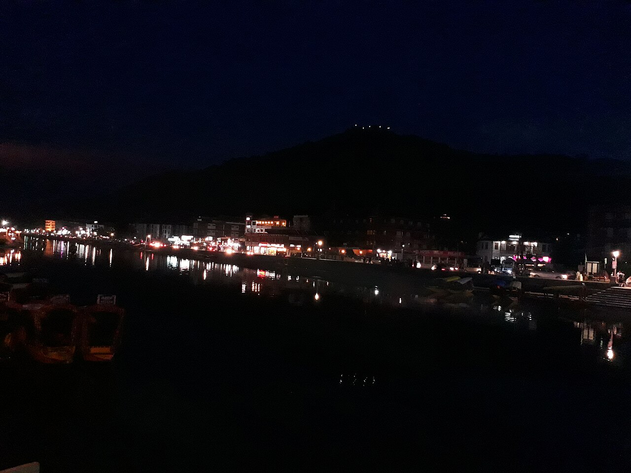 Streetlights reflecting on the water along a Srinagar boulevard