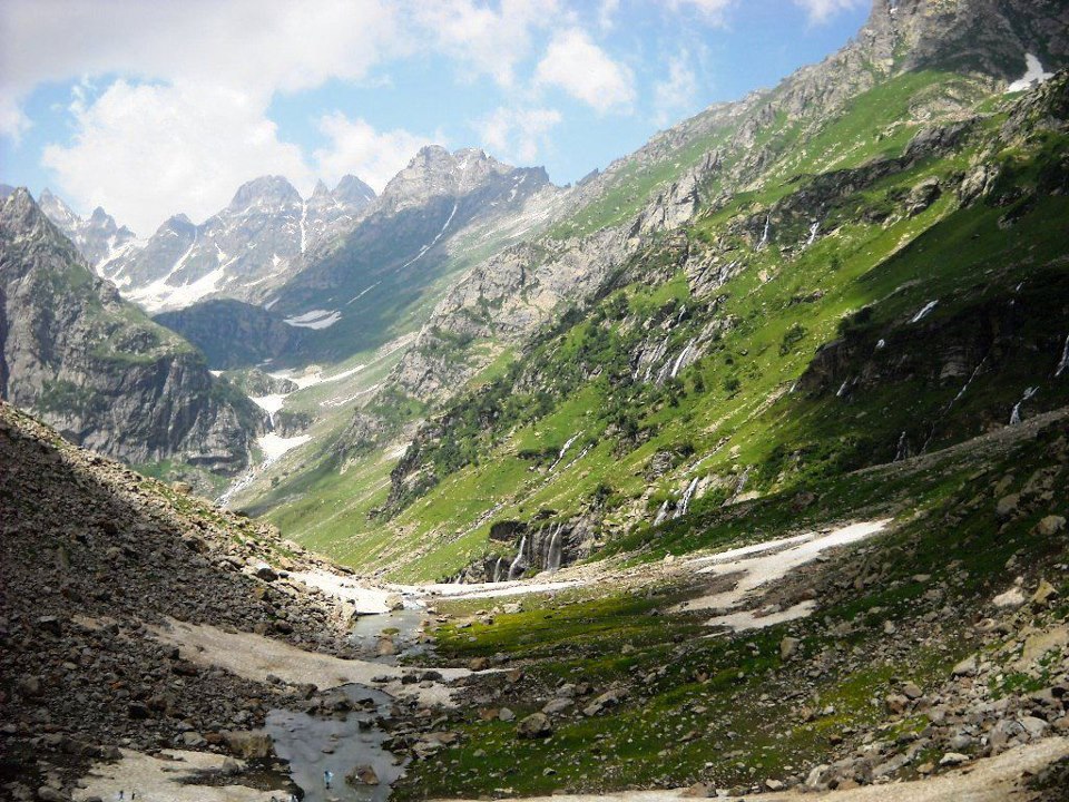 Tour vehicle parked near scenic mountain viewpoint in Kashmir