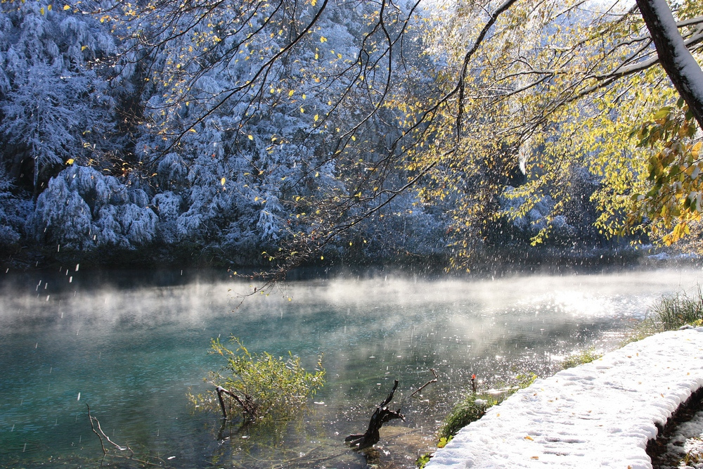 Mist lifting off the surface of a calm lake on a winter morning.