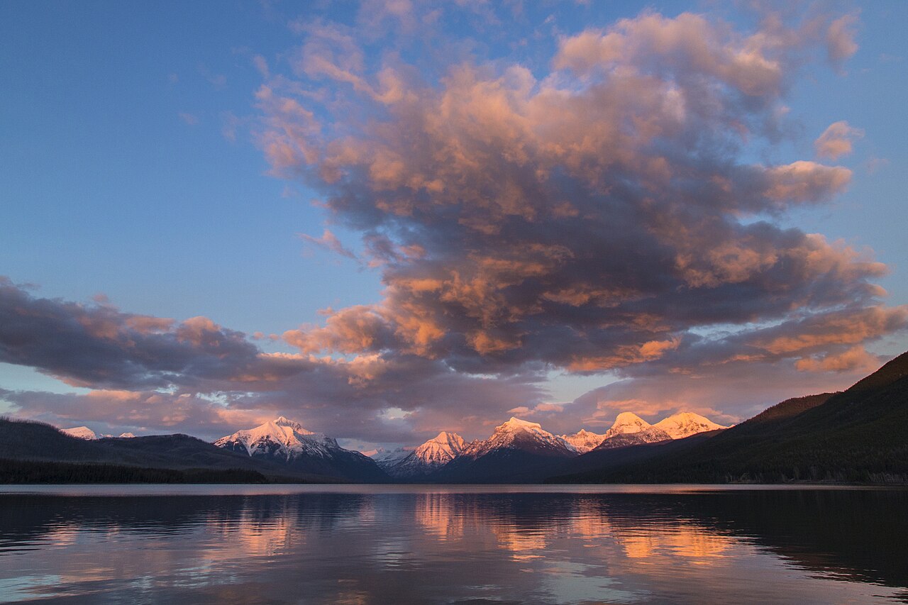 Wide panoramic view of mountains reflected in a massive lake