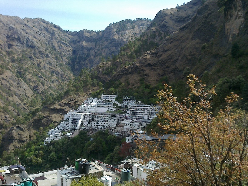 Illuminated Vaishno Devi Bhavan complex at night against the mountains