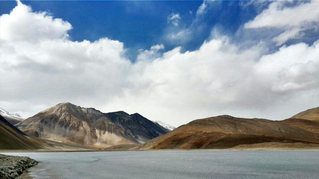 Travel vehicle driving on a winding mountain road in Ladakh