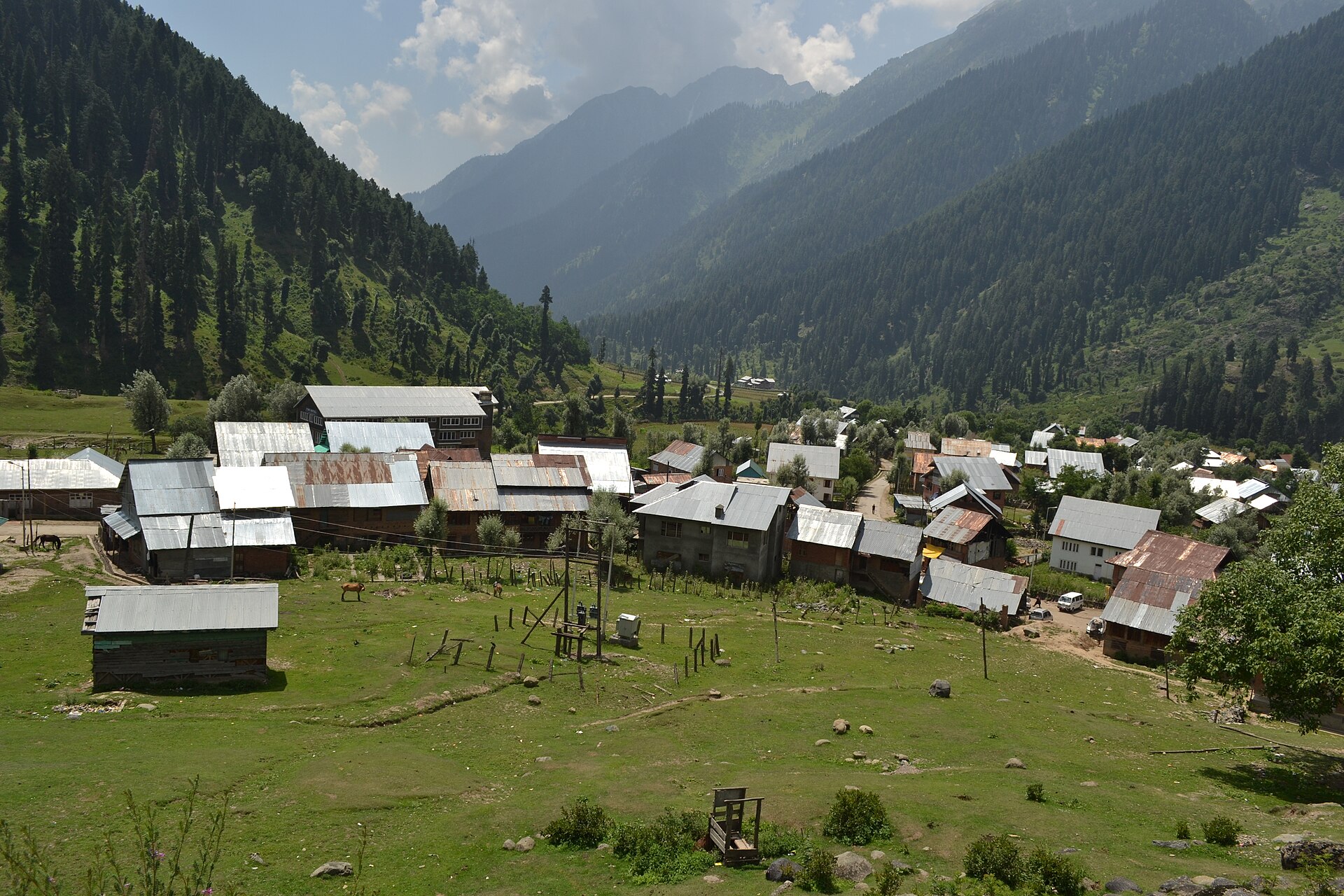 Traditional wooden alpine cottage with mountain backdrop in Aru Valley