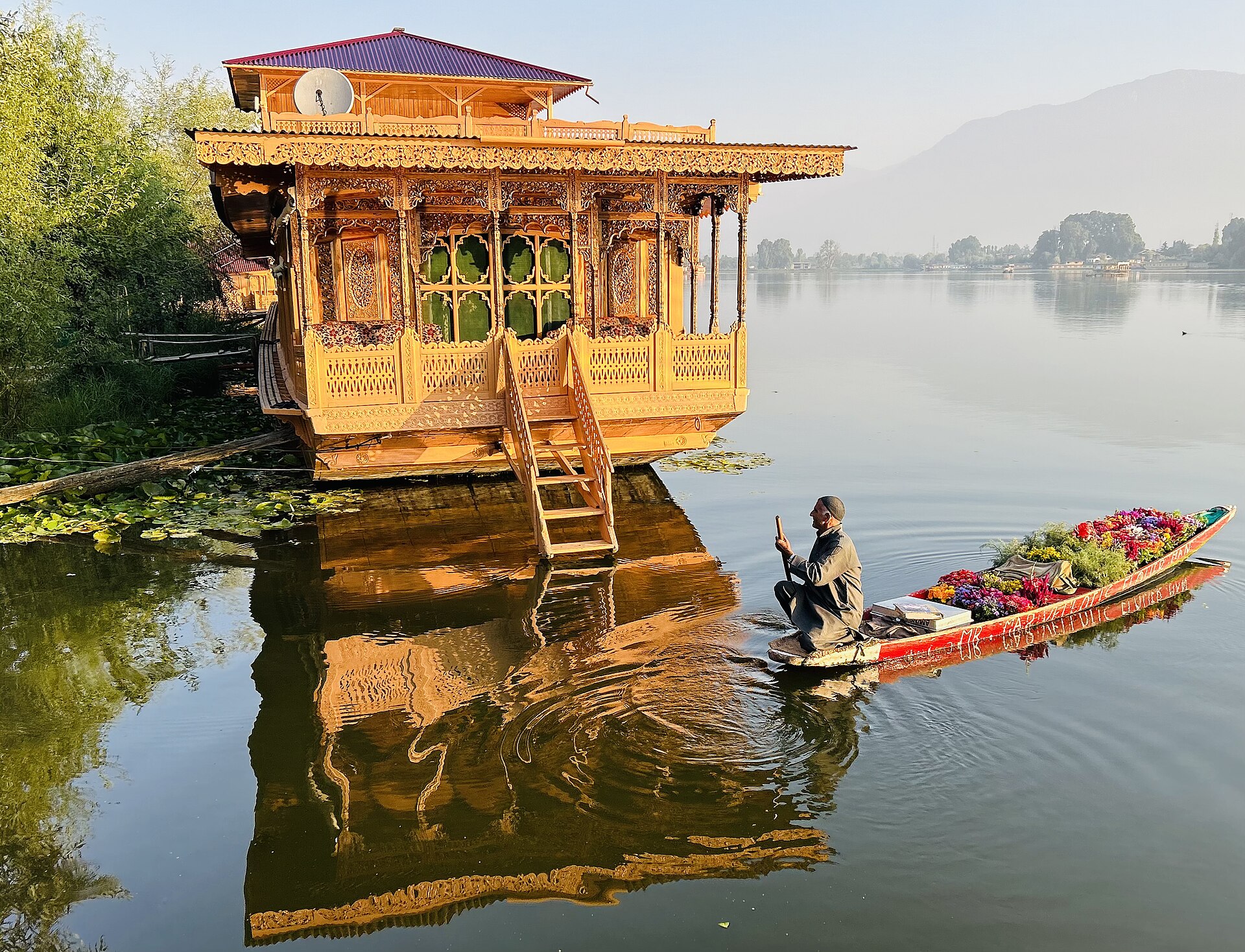 A serene view of Nigeen Lake at sunrise from a boat