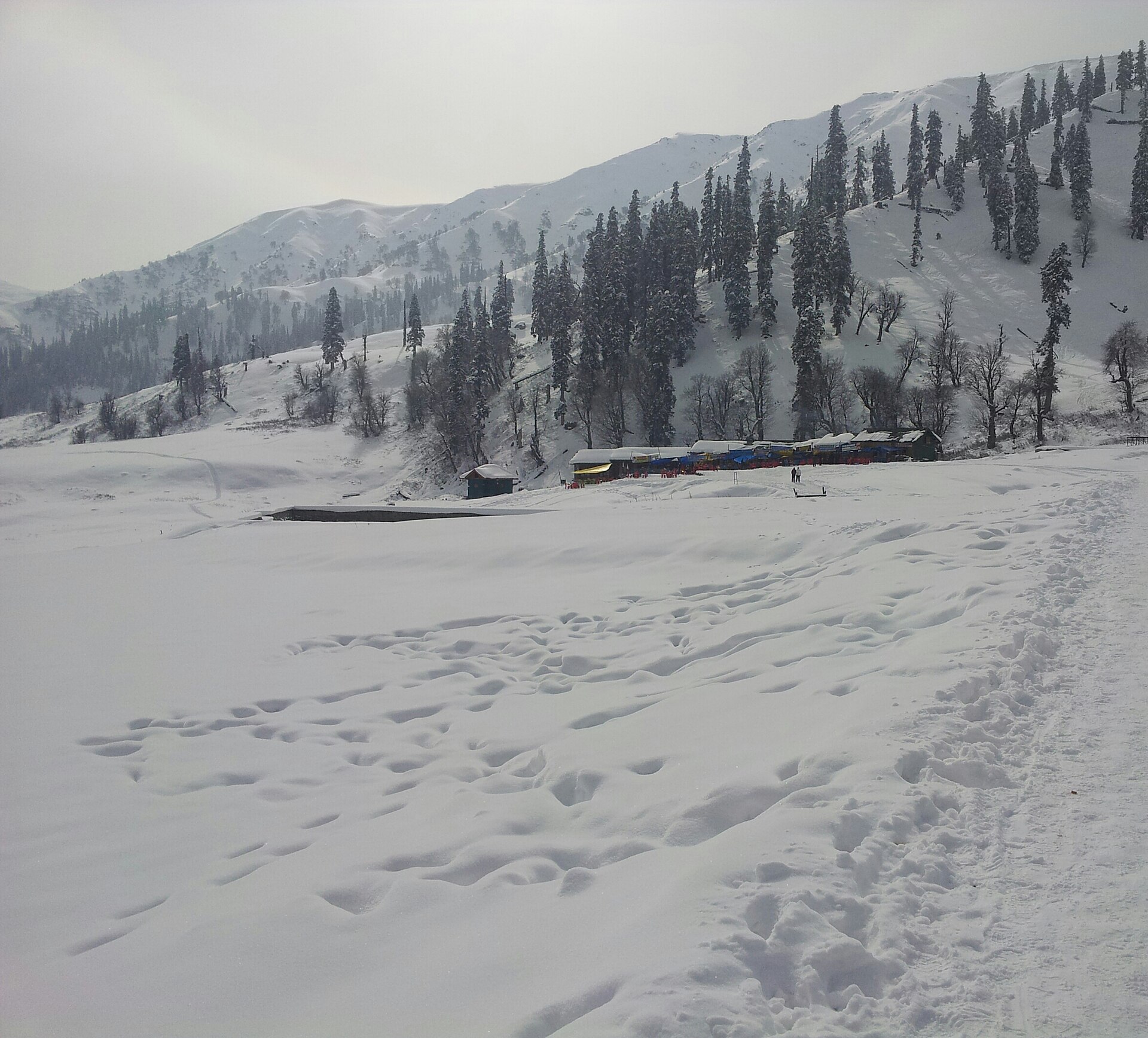 Wooden alpine chalets buried in deep snow in Gulmarg village