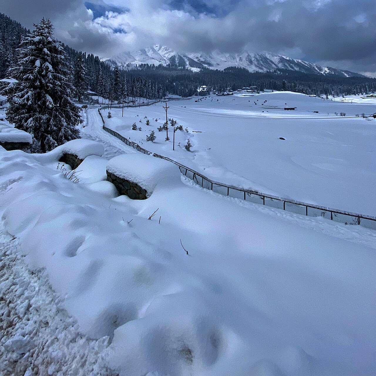 Clear road cutting through deep snow banks in Kashmir