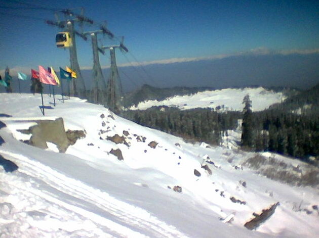 Gondola car rising over snowy peaks