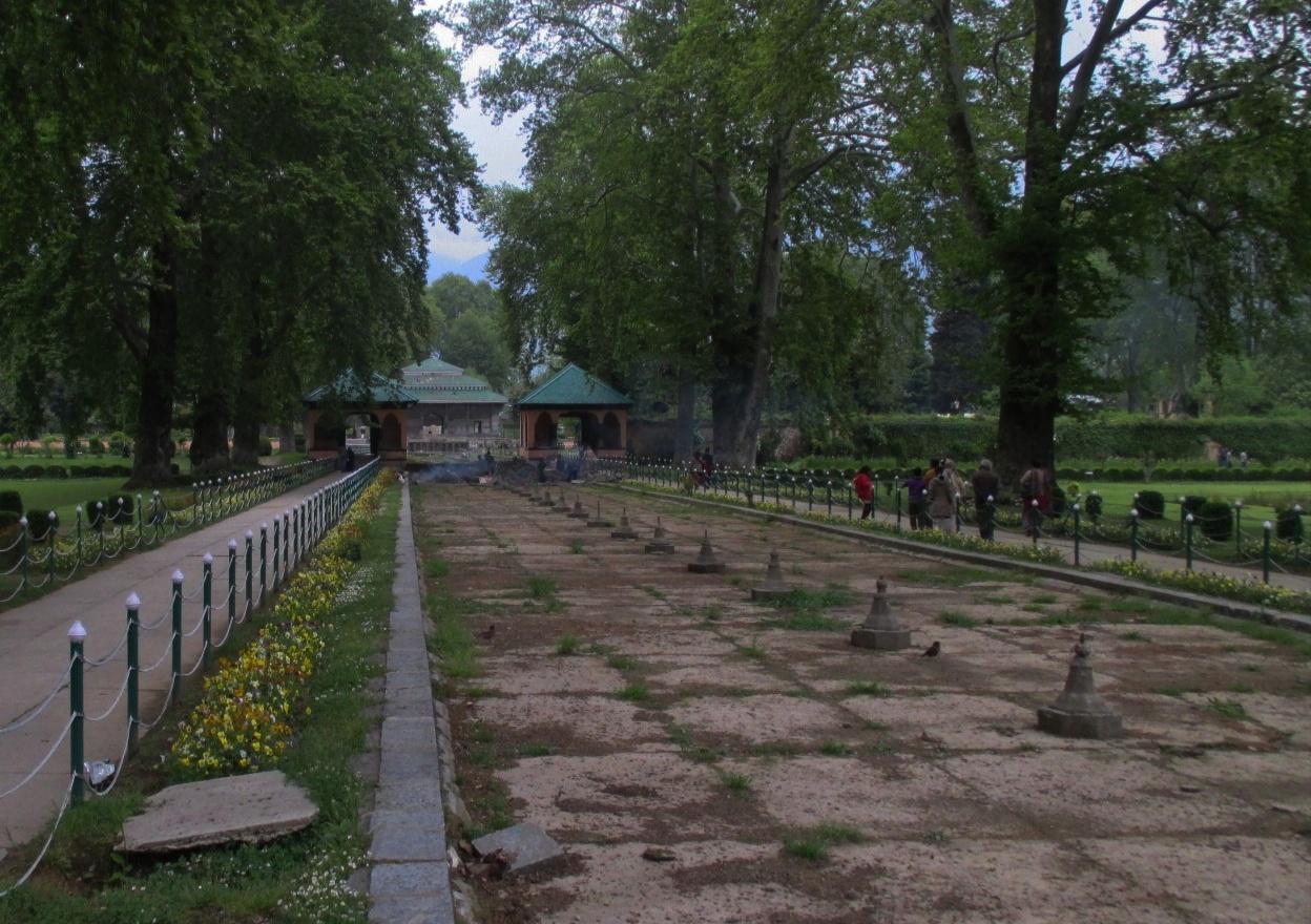 Historic stone pavilion and leafless trees in a Srinagar garden