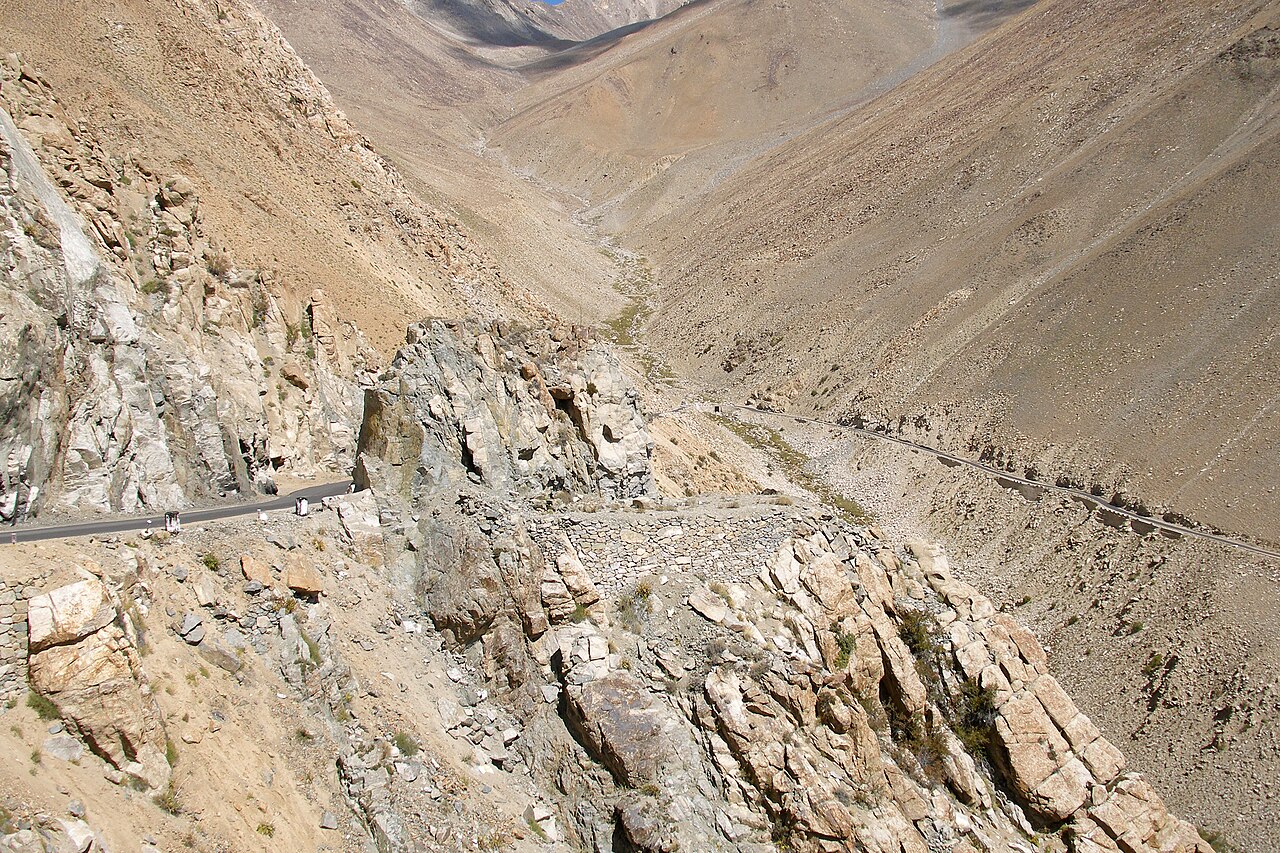 Vehicles waiting at a mountain road security checkpoint.