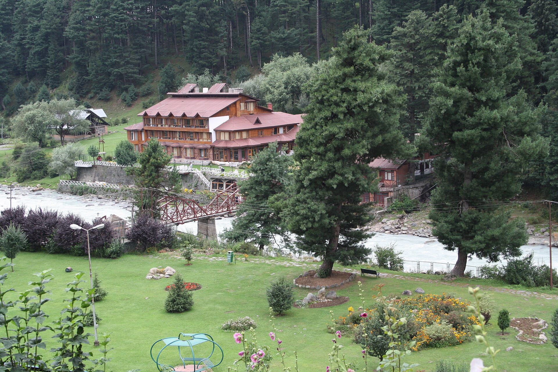 Rushing Lidder river cutting through pine forests in Pahalgam