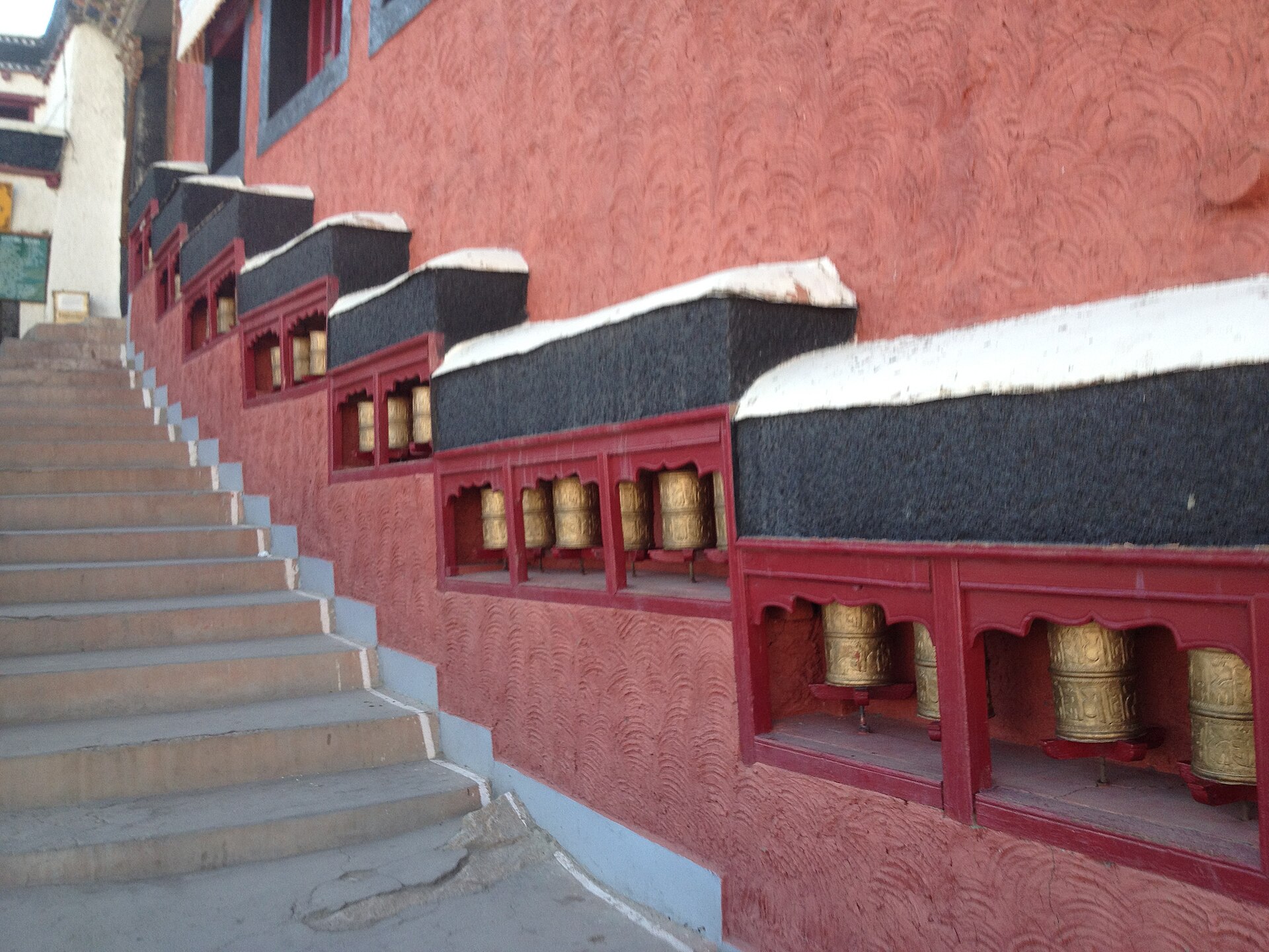 Vehicles parked at the base of Thiksey Monastery parking area
