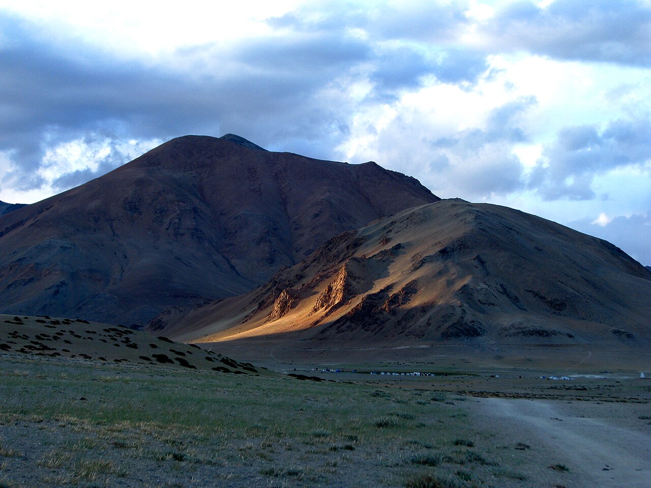 The sun setting behind high mountain peaks.