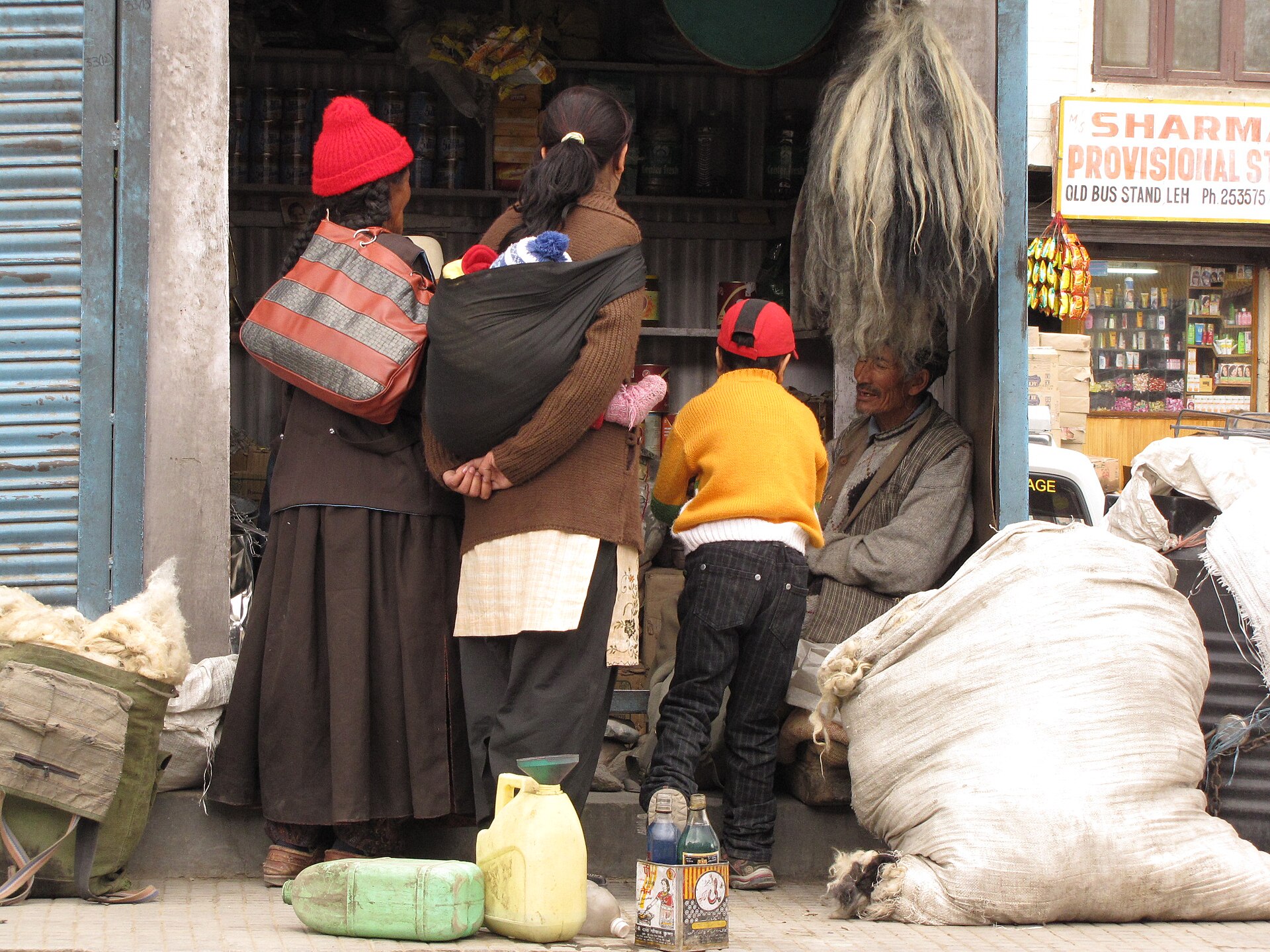 The busy public bus station in Leh with mountain views.