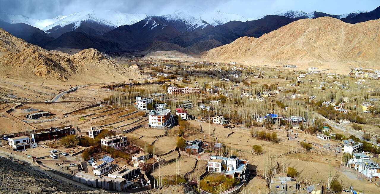 Leh town sprawling across the valley floor under morning sun