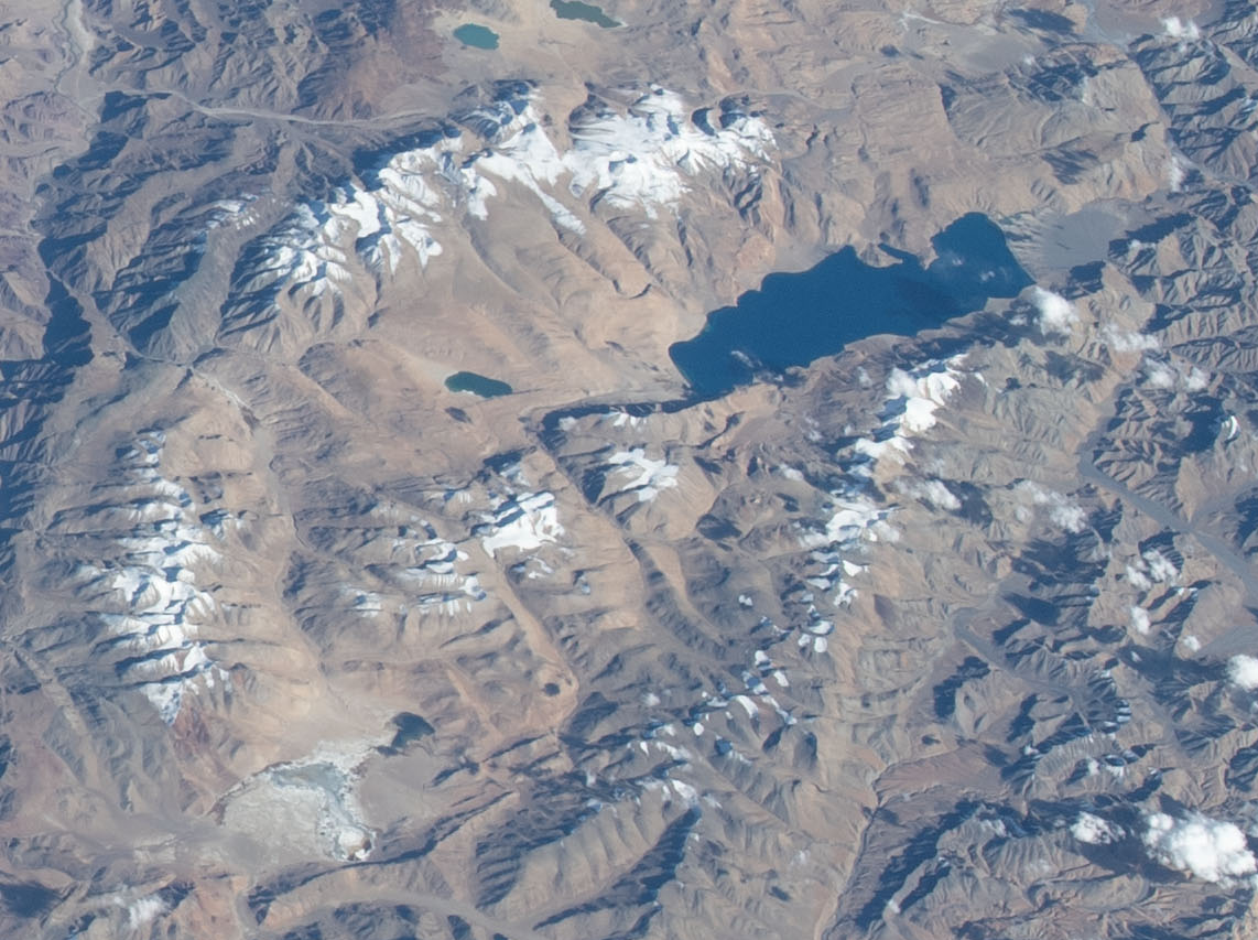 A remote dirt road winding through the barren mountains of Ladakh