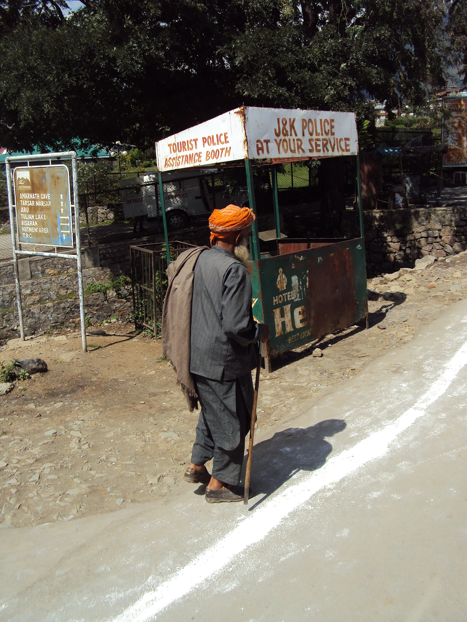 A tourist cab driving along a clear mountain road in Pahalgam
