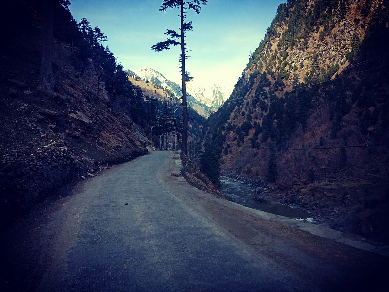 Well-paved road winding through green hills.