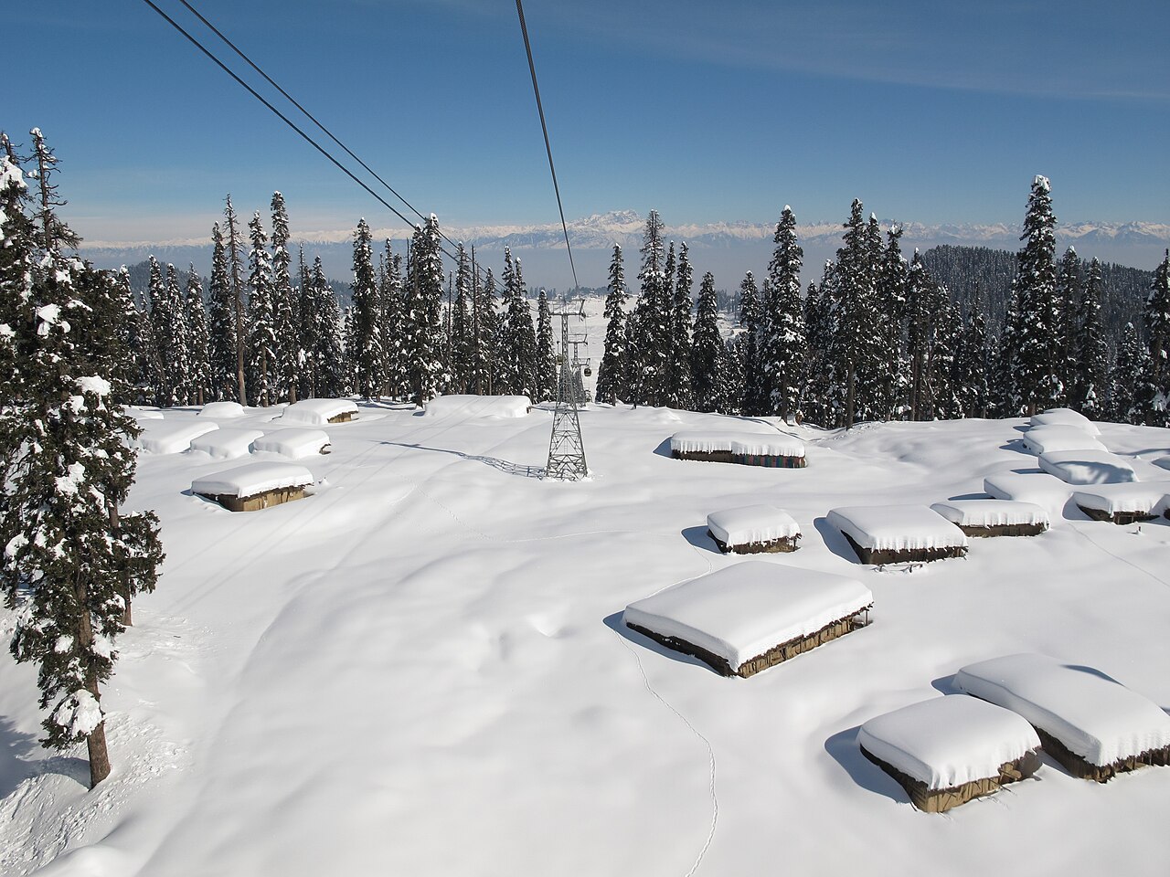 Gondola cabins moving across snow-covered mountains in Gulmarg