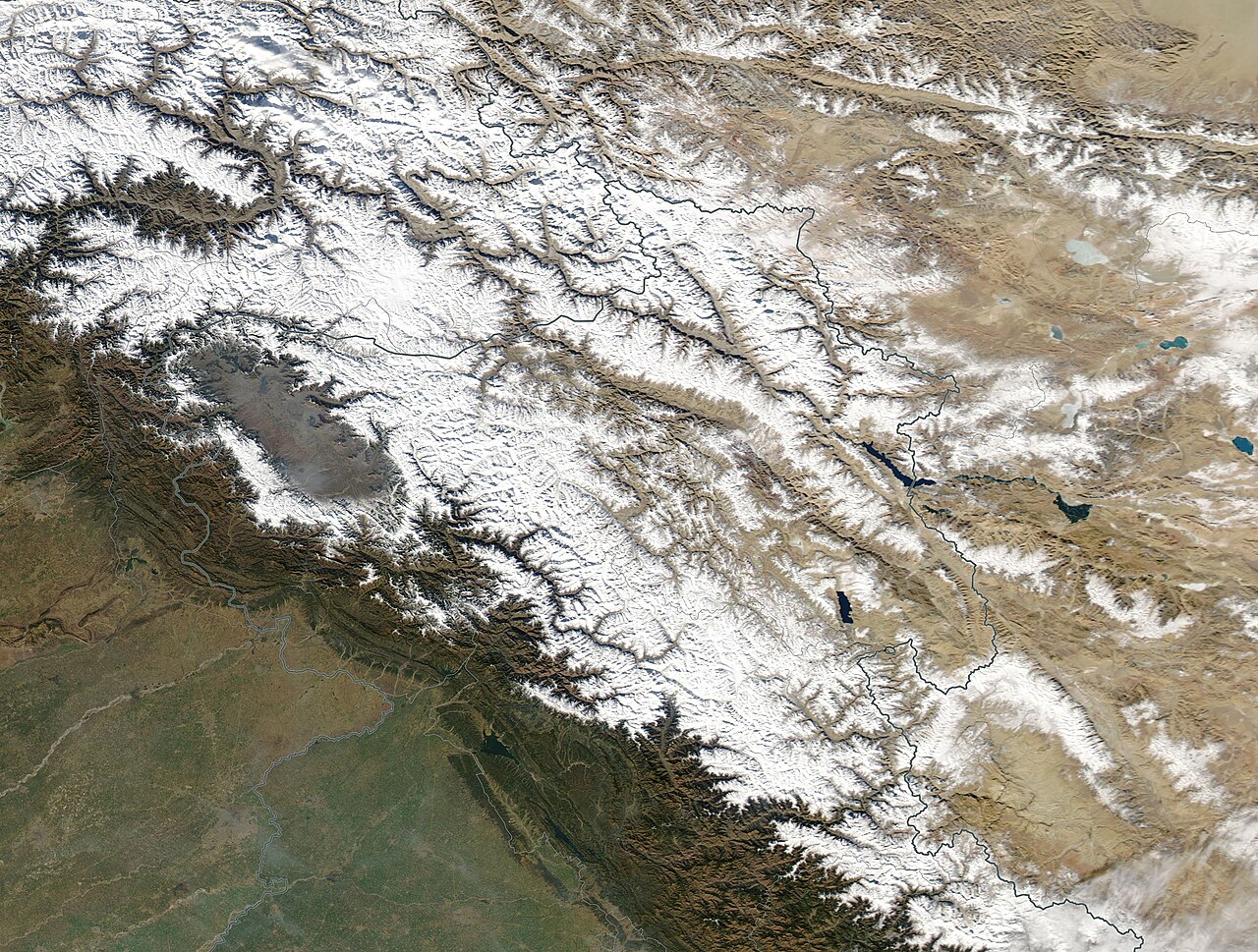 A snow-covered road and frozen landscape in the Sonmarg region during winter.