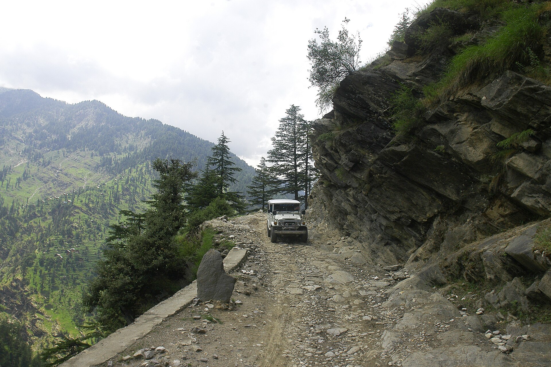 Tour cab driving along scenic mountain highway in Kashmir