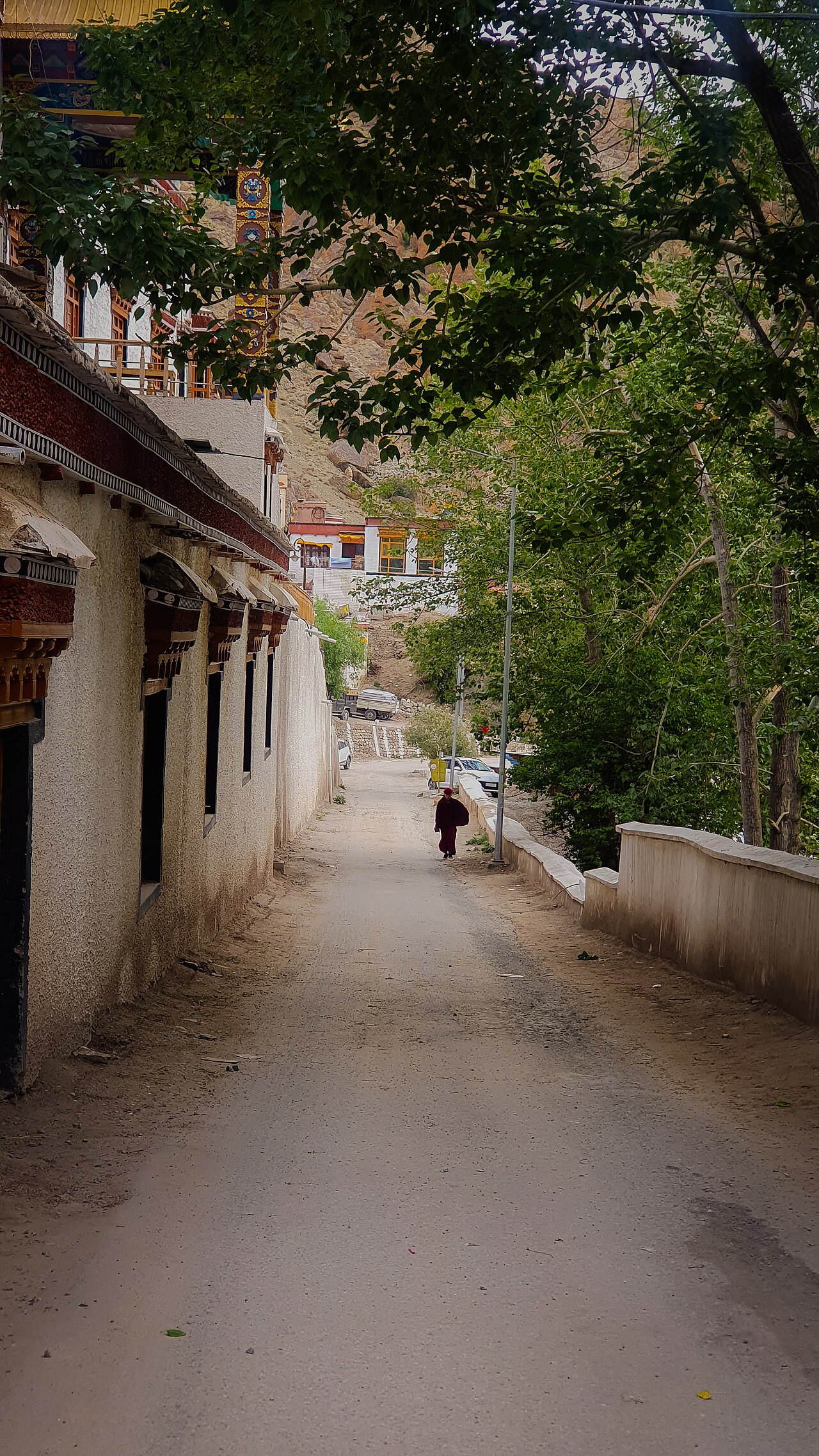 Monk walking across a stone monastery courtyard in Ladakh