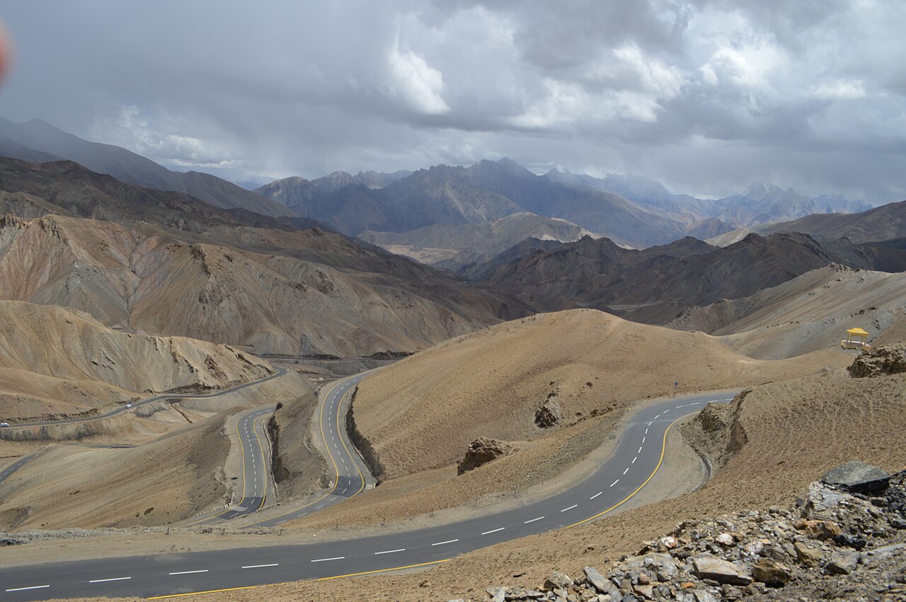 Smooth paved road leading through green countryside in Kashmir