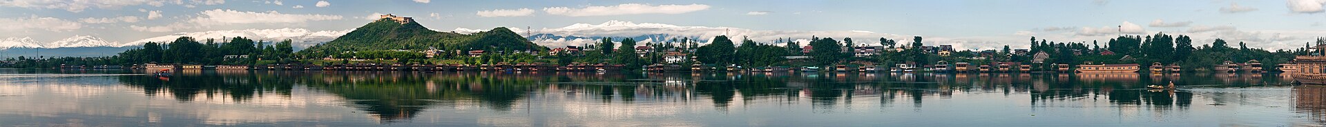 A person kayaking on the calm surface of Nigeen Lake