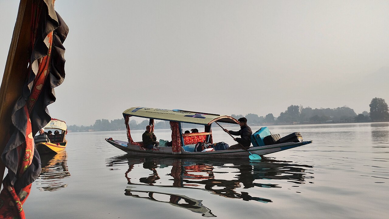 A traditional wooden shikara boat on the lake