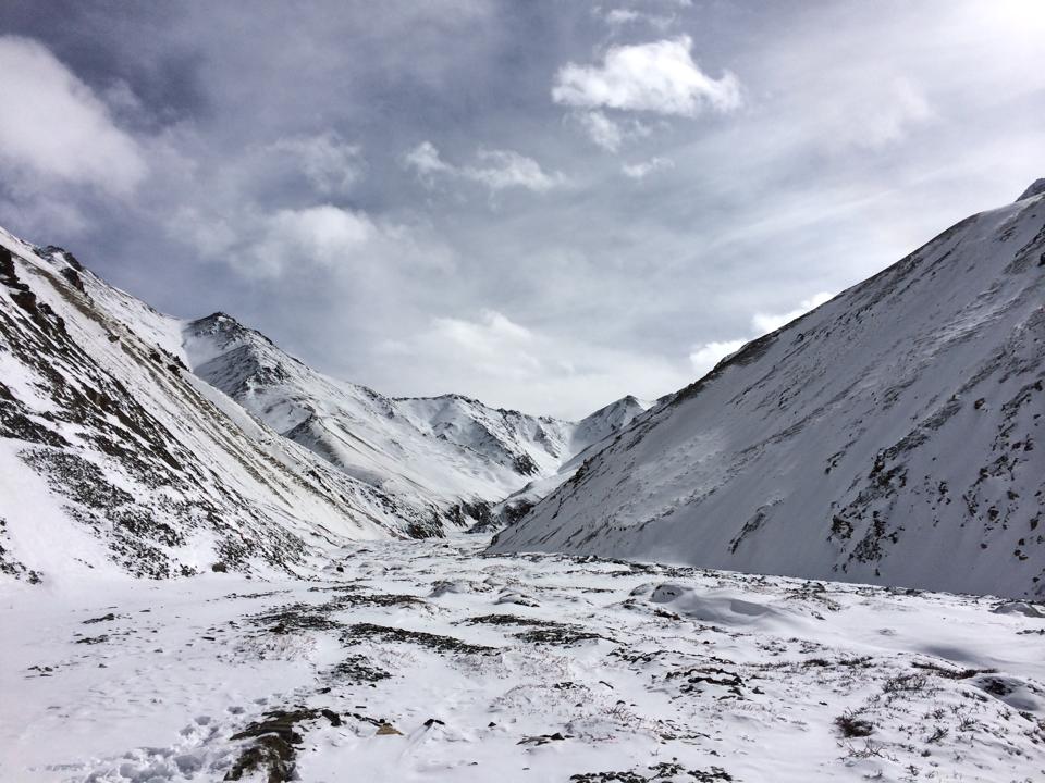 Snow-capped mountain pass under blue sky in Ladakh