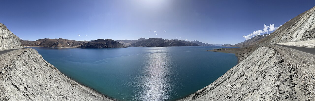 Calm blue water of Pangong Tso reflecting surrounding peaks