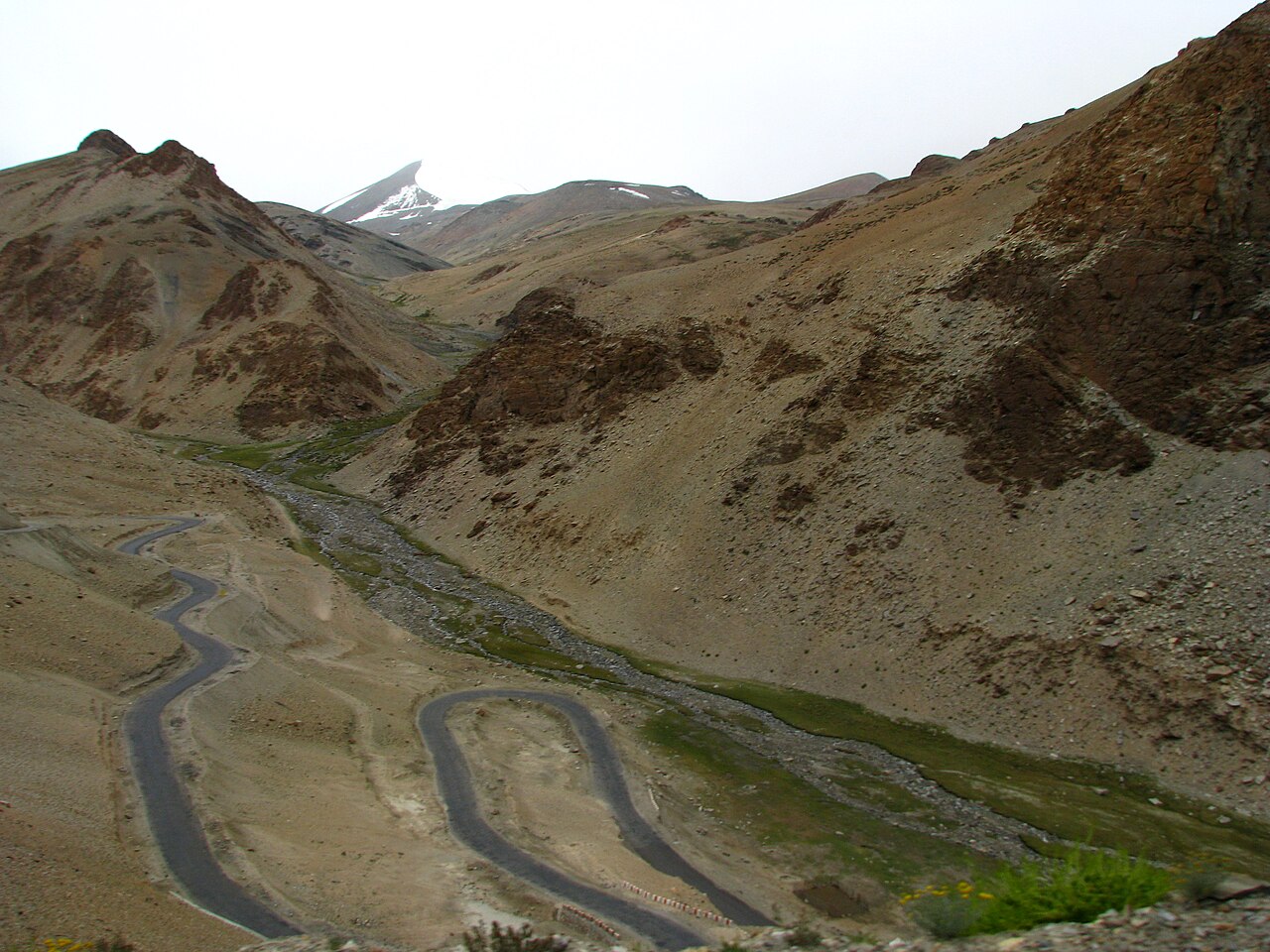 A car parked on the roadside in the mountains.