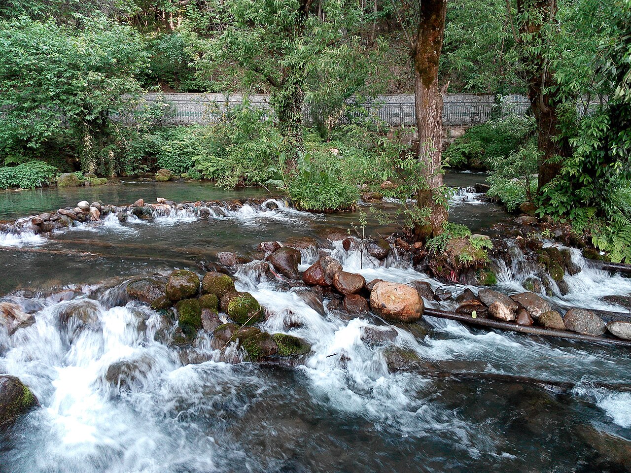 Crystal clear water flowing through stone channels in the garden