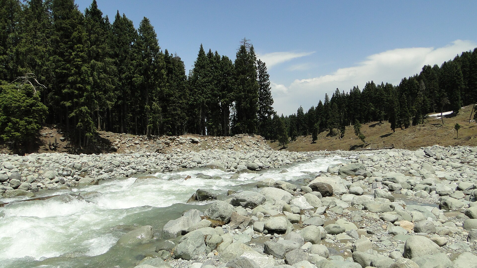 Wide green meadow and winding river in Doodhpathri Kashmir